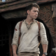 Tom Holland wears a linen henley and looks off into the distance in the Uncharted movie.